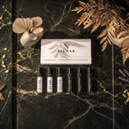 Top-down flat lay view of SIGNAR Discovery Set box with six 5ml perfume tester vials on dark green marble.
