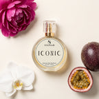 SIGNAR ICONIC Extrait De Parfum for Her 50ml bottle, styled in a flat-lay with a pink peony, a white orchid, and passion fruit on a warm cream background.