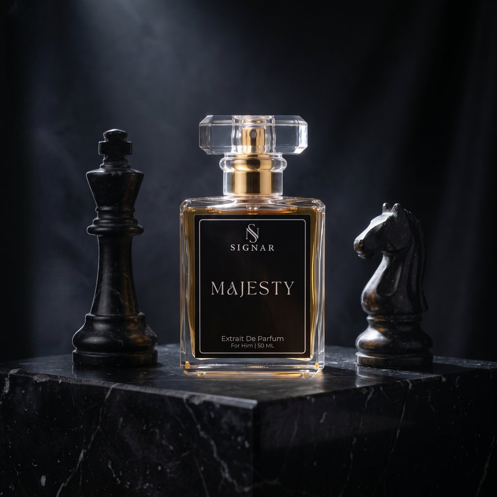 SIGNAR Majesty Extrait De Parfum perfume bottle in a clear glass bottle with a gold cap and black label, displayed on a black marble pedestal flanked by two black chess pieces against a dark background.