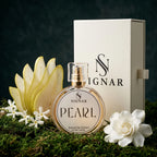 SIGNAR Pearl Extrait De Parfum 150ml perfume bottle with a gold cap, displayed in front of its cream-colored packaging box, surrounded by white flowers and a yellow flower on a green mossy surface against a dark textured background.