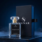 SIGNAR Phantom Extrait De Parfum perfume bottle in a clear glass bottle with a gold cap, standing next to its dark navy blue presentation box on a dark reflective surface with atmospheric smoke.