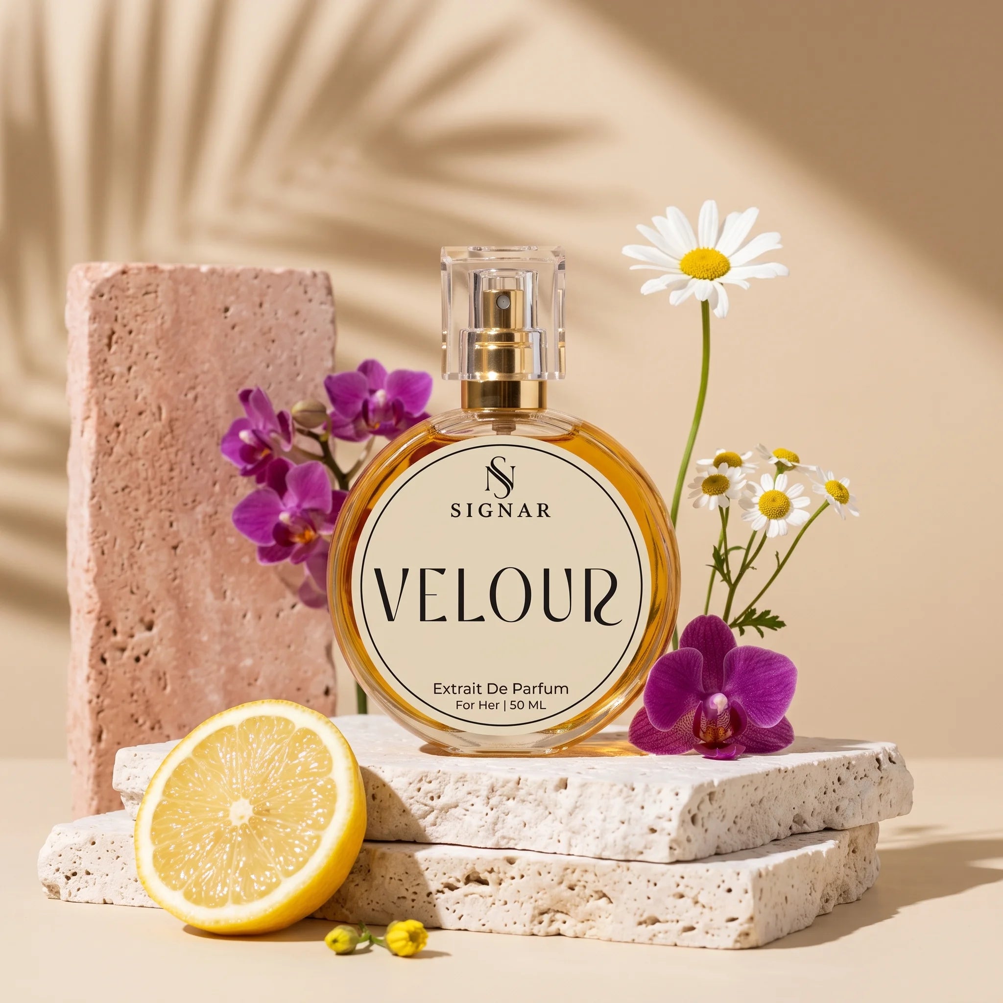 SIGNAR VELOUR Extrait De Parfum for Her, 150 mL round glass bottle with a gold cap, styled on stacked stone slabs with a lemon half, purple orchids, daisies, and a pink stone block against a warm beige background with leaf shadows.